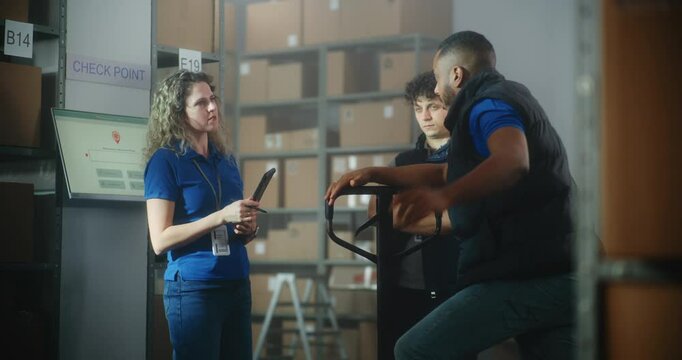 Female logistics manager with tablet computer talks to colleagues, gives instructions for delivery. Multiethnic sorting center employees working in warehouse facility of postal service or online store