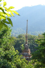 Thai temple located in the middle of the forest. behind the mountain