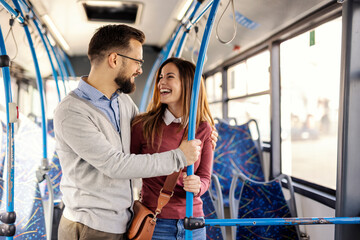 Happy passenger couple hugging in city bus and smiling at each other. © Dusan Petkovic