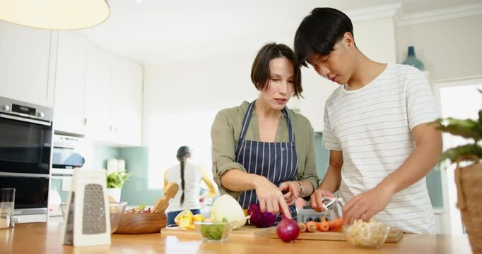 Cooking together, mother and son preparing vegetables in modern kitchen
