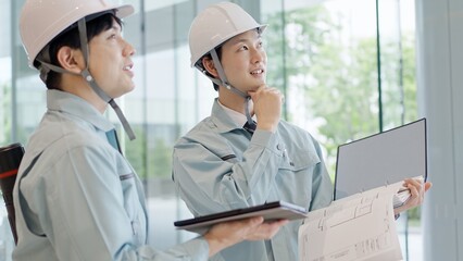 打ち合わせをする作業服を着た男性