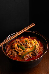 Spicy ramen, vegetables, and meat on the table