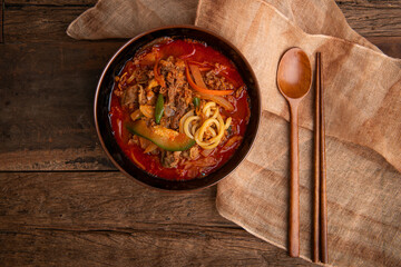 Spicy ramen, vegetables, and meat on the table