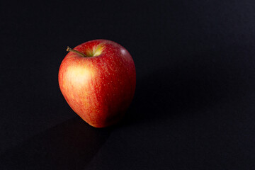 Close up of a red apple on a black background