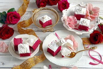 Close up of a plate with delicious cake rolls and vibrant roses beautifully arranged on a table
