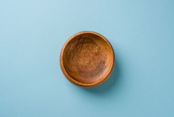 Top view of wooden snack bowl on blue background