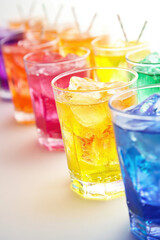 A vibrant array of colorful, refreshing drinks in clear glasses with ice, capturing the essence of refreshing summer beverages.