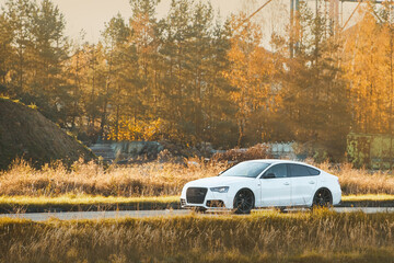 White luxury car on country road