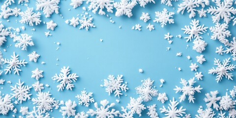 Delicate snowflakes in various sizes scattered on a light blue backdrop creating a decorative border with ample copy space in the center.