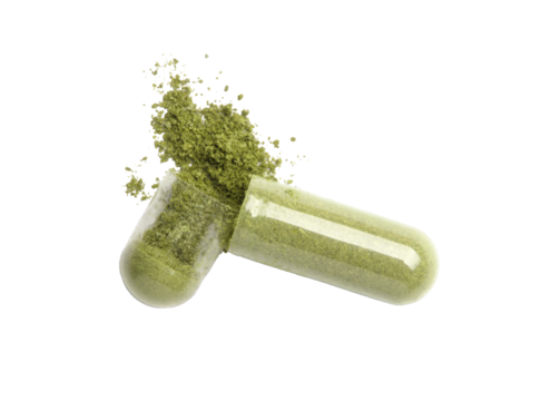 Green powder capsule pill isolated on white background. Top view. Flat lay.