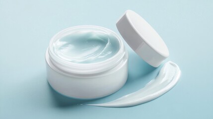 8.A sleek white jar of skincare cream open with a smooth texture, placed on a pastel light blue background. Beside it, an elegant smear of the cream spreads in a soft curve, showcasing its silky