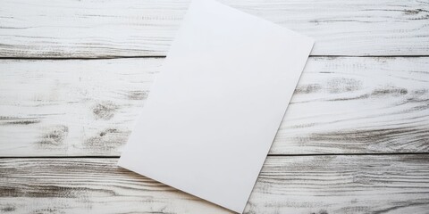 White blank sheet of paper on a rustic white wooden table positioned centrally with ample space for text above for templates or mockups.