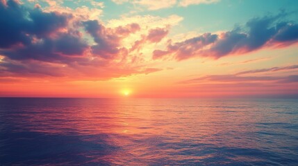Obraz premium Vibrant sunset over calm ocean waters with colorful clouds illuminating the sky