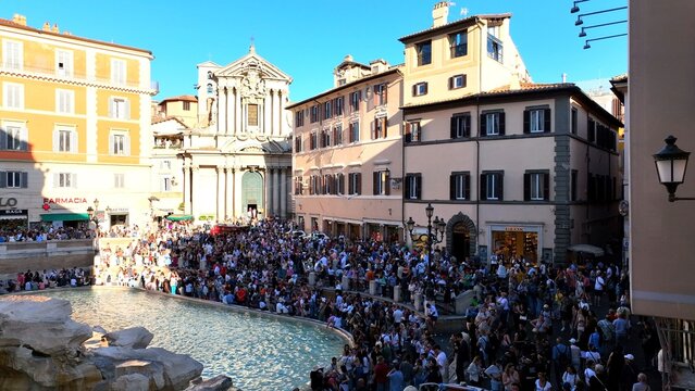 Folla di turisti in visita alla fontana di Trevi a Roma, Italia.
la Fontana di Trevi gremita di visitatori in una giornata estiva.
