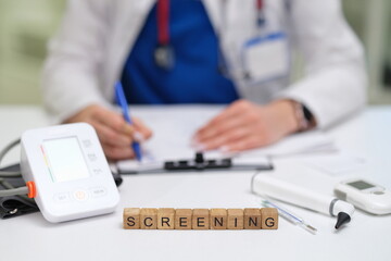 A healthcare professional performing a health screening with medical devices and necessary paperwork