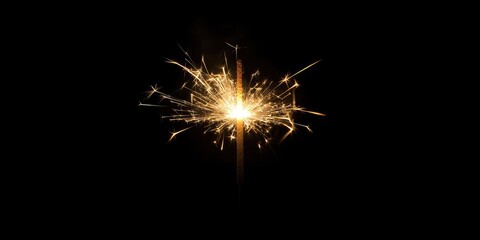 Fototapeta premium Bright sparkler emitting golden sparks in center against a deep black background creating a festive and celebratory atmosphere.