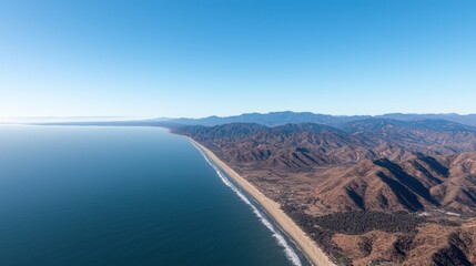 Aerial view of a coastal landscape with mountains in the background.