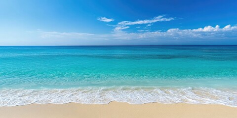 Tranquil beach scene with turquoise sea meeting soft sandy shore under a clear blue sky, ideal for holiday promotions and ads.