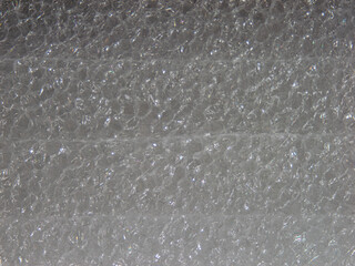 A blurry image of a white surface with a few small bubbles