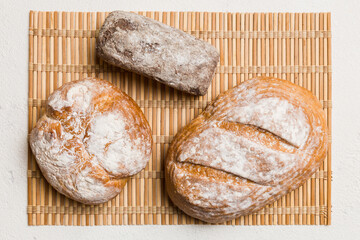 Assortment of freshly baked bread with napkin on rustic table top view. Healthy unleavened bread. French bread