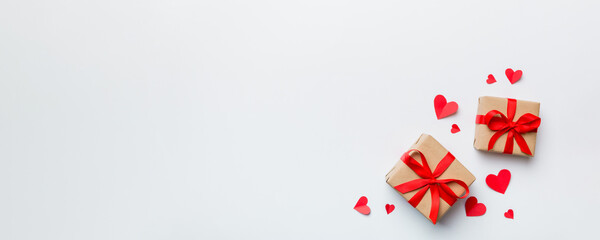 Valentine day composition: red gift box with bow and heart. Christmas present. View from above. Space for text. Holday greeting card