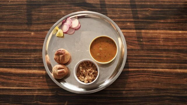 authentic indian traditional food dal bati churma served in steel plate from top angle video is taken at rajasthan. Dal baati churma is a popular dish in the state of Rajasthan, India.