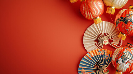 Colorful paper lanterns and fans are beautifully arranged against a vibrant red background, creating a festive and cultural atmosphere.