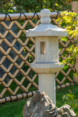 apanese garden in Galitskrgo park in Krasnodar Japanese garden lantern Yukimi-gata or “snow lantern” is squat lantern with wide roof. Lantern against backdrop of greenery of garden.