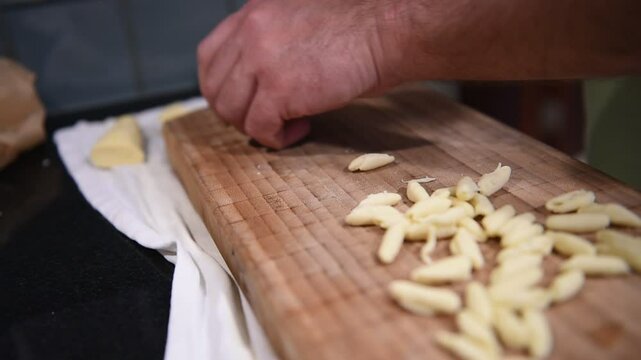 pasta fatta in casa con le mani su di un tagliere di legno