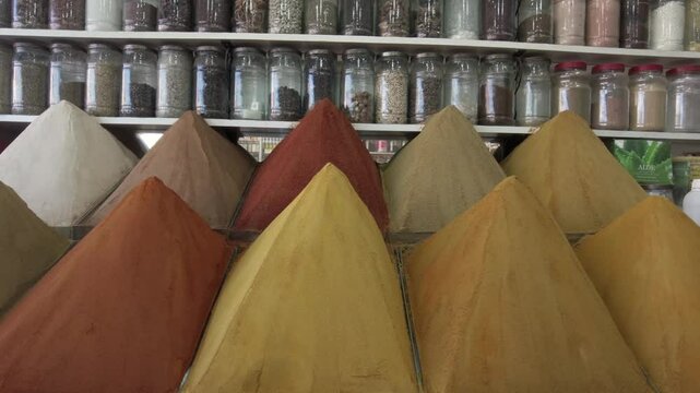 display of spices for cooking in the shape of a pyramid in a shop inside the souq of Marrakech, spices and flavors typical of Moroccan tjine cuisine, curry, cumin and paprika