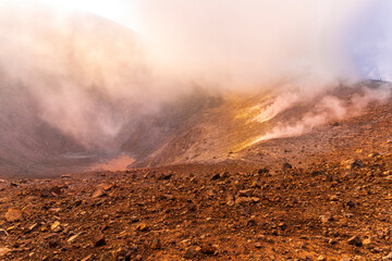 Aerial landscape view of volcano crater with smoke coming. An active erupting volcano with...
