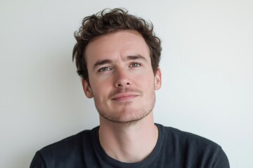 Fototapeta premium Headshot of a young man with a cheeky smirk and a raised eyebrow, conveying confidence and a playful attitude on a clean white background