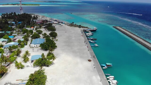 Aerial drone footage of a Maldives island in South Ari Atoll, capturing a stunning view of the boat jetty over crystal-clear turquoise waters.