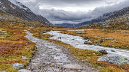 Mountain path alongside rushing stream, autumnal colors, dramatic sky