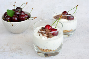 Cherry Yogurt Parfaits with oats and chocolate in a drinking glass 