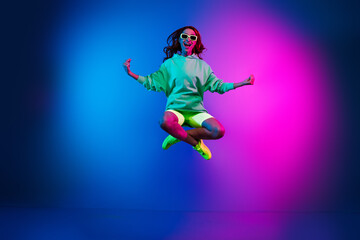 Full length photo of adorable lovely girl wear green hoodie jumping high enjoy yoga isolated pink...