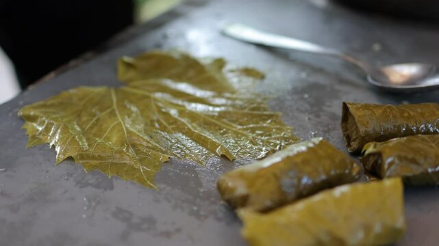 People cook dolma food.
Grape leaves stuffed with minced meat.