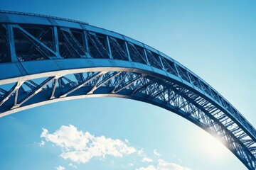 Obraz premium Steel bridge arch against a bright blue sky.