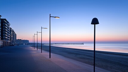 Serene beach promenade at dawn with lampposts and calm waters.