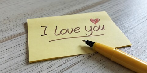Sticky Note with the Text "I Love You" and a Heart Symbol Next to a Pen