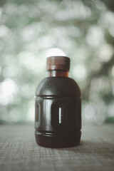 Fresh black coffee in a plastic bottle against nature background