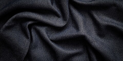 Textured black cotton denim fabric with soft folds and ample negative space for design use, showcasing a deep dark hue with detailed fabric weave.