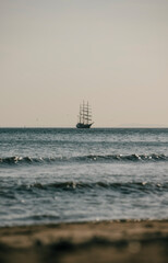 A large ship sails in the ocean, with the sky in the background. The scene is calm and peaceful, with the ship being the only object visible
