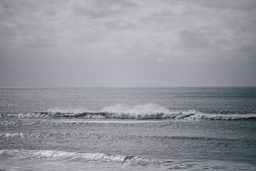 The ocean is calm and the sky is cloudy. The water is a deep blue color