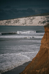 The ocean is calm and the sky is cloudy. The waves are small and the water is clear