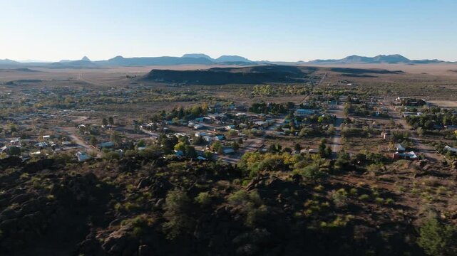 Aerial orbit overlooking rural Texas town at sunrise from mountaintop, West Texas's Fort Davis near Big Bend National park in 4k