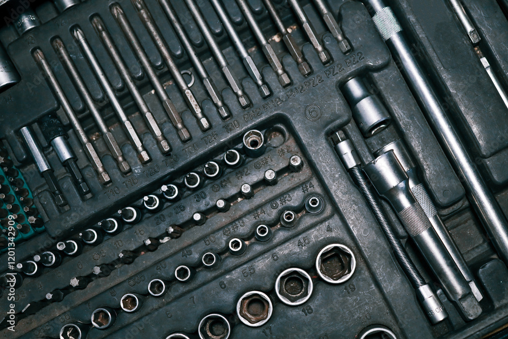 Poster close-up of a toolset including various screwdrivers, sockets, and extensions in a compact organizer