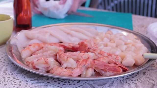 Scallops without shells, shrimp and squid on a plate, cooking seafood
