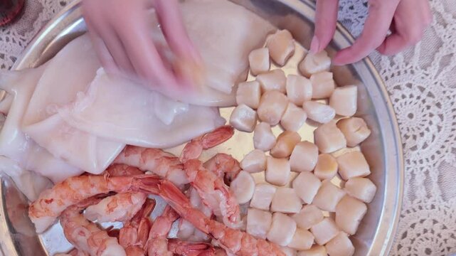 Scallops without shells, shrimp and squid on a plate, cooking seafood