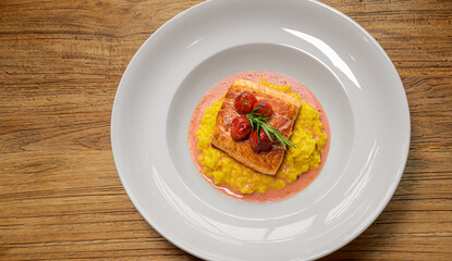 salmon fish fillet on saffron risotto and vanilla-blood orange fumet